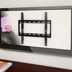 a flat screen tv mounted to the side of a wall with a flower on it