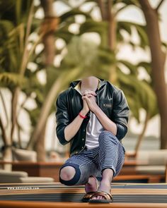 a woman sitting on the ground with her hands clasped in front of her face while wearing sandals and a leather jacket