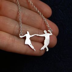 a person holding onto a silver chain with two people on it