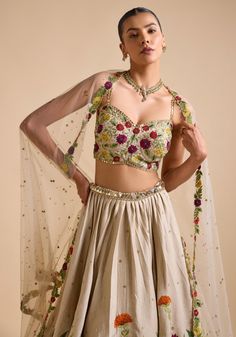 Elevate your ethnic wardrobe with Ivory Embroidered Lehenga. Crafted from luxurious silk, the lehenga features intricate thread, sequin, and cutdana embroidery in stunning floral patterns. Teamed with a modern cut embroidered strappy blouse and a beautifully adorned dupatta. This ensemble is ideal for a bride or bride-to-be, ensuring an unforgettable, elegant look for your special day. Composition : Skirt & Blouse - Silk, Dupatta - Net Care: Dry Clean Only and Vacuum Storage This product can be Tissue Silk Sets With Floral Embroidery For Reception, Floor-length Floral Embroidery Choli For Festive Occasions, Navratri Floral Embroidered Organza Sharara, Navratri Organza Sharara With Floral Embroidery, Floral Embroidered Sharara For Receptions And Festivals, Floral Embroidered Sharara For Festivals And Receptions, Festive Floor-length Floral Embroidery Choli, Anarkali Set With Floral Embroidery In Tissue Silk, Floor-length Lehenga With Floral Embroidery For Festivals