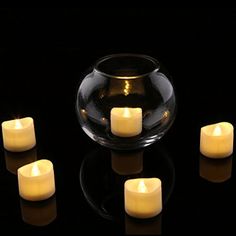 five lit candles sitting in front of a glass bowl