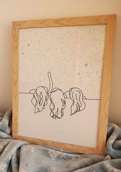 a drawing of two dogs in the snow on a blanket next to a wooden frame