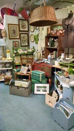 a room filled with lots of furniture and pictures on the wall, including boxes and baskets