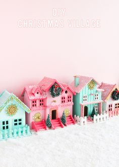 a pink and blue christmas village with snow on the ground in front of it that says diy christmas village