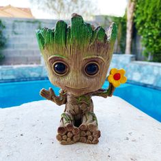 a baby groote planter sitting on top of a table next to a pool