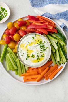 a white plate topped with carrots, celery and tomatoes