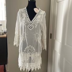 This White Embroidered Dress Would Be Perfect For A Beach Cover Up Or Summer Dress. The Detailing Of The Fabric Is Very Elegant. Elegant White Tunic With Floral Embroidery, Elegant White Spring Tunic, Cream Embroidered Summer Beach Dress, Elegant Embroidered Fitted Tunic, Cream Embroidered Beach Dress For Spring, Spring Cream Embroidered Beach Dress, White Lace Trim Tunic Dress, White Embroidered Tunic Dress For Spring, Elegant White Embroidered Dress With Hem Detail