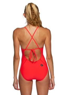 a woman in a red one piece swimsuit with an open back and cross straps