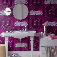 a white sink sitting under a bathroom mirror next to a purple and white wallpaper