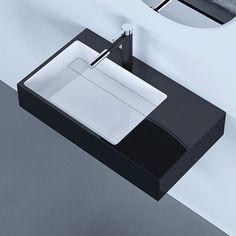 a black and white bathroom sink sitting under a mirror next to a wall mounted faucet