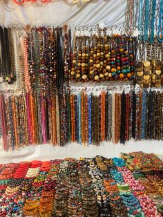 an assortment of bracelets and necklaces on display at a market stall in india