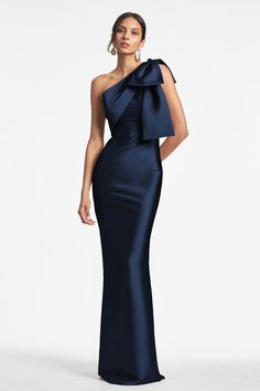 The Bonnie column dress features a sleek sleeve of double-face stretch Mikado with an asymmetric one-shoulder and elegant bow at the shoulder. This modern silhouette is sure to make a statement at any event. Crafted with an eye for detail, you can expect long-lasting quality and timeless style from this piece. *This style runs generously through the bust, waist and hips. If you want a closer fit as pictured we suggest sizing down. Details: Model is 5'10" wearing size 2 Full-Length, 60" from top of shoulder to bottom hem Side Zipper Double Face Stretch Mikado 81% Polyester - 14% Nylon - 5% Elastane Imported Style #F231G40-415 Mermaid Party Dress, Elegant Black Dress, Dresses Formal Elegant, Looks Party, Evening Gowns Elegant, Column Gown, Maxi Dress Prom, Formal Party Dress, فستان سهرة