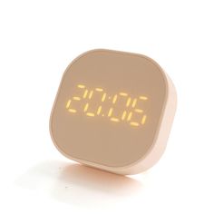 an alarm clock with yellow numbers on the front and back sides, sitting on a white surface