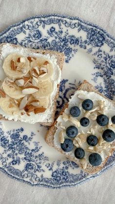 two pieces of bread with bananas and blueberries on it sitting on a plate next to another piece of bread