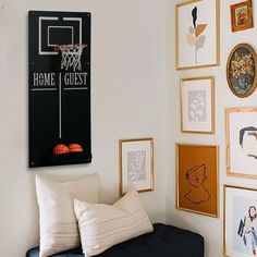 a living room filled with lots of framed pictures and art on the wall next to a couch