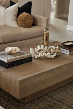 a coffee table with two books on it and a vase sitting on top of it