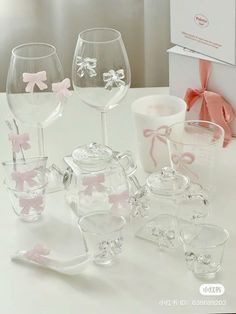 three wine glasses sitting next to each other on a white table with pink bows around them