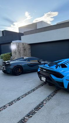 two blue sports cars parked next to each other