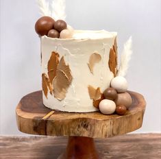 a close up of a cake on a wooden stand with feathers and eggs around it