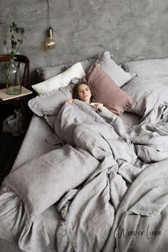 a woman laying in bed under a blanket