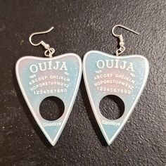 Unlock The Mysteries Of The Universe With These Mesmerizing Ouija Planchette Earrings. Handmade Resin Planchette Design Light Pink And Light Blue Hues With Shimmering Silver Glitter Lightweight French Hook Style For All-Day Comfort These Enchanting Earrings Tap Into The Energy Of The Ouija Board, Allowing You To Connect With The Spiritual Realm. The Ethereal Pastel Colors And Glittering Accents Create An Otherworldly Look That's Sure To Turn Heads. Whether You're A Crystal-Loving Mystic Or Just Goth Earrings, Ouija Board, Cute Emo, Emo Goth, Quirky Gifts, West London, Organza Gift Bags, Black Glitter, Diy Earrings