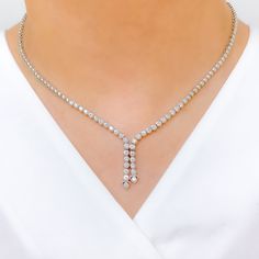 Elevate your style with this Graceful Diamond Tassel Necklace Set. Crafted with 18k white gold and 2.94ct diamonds in round shape, this set has a set length of 17" and a drop length of 1". It features a push lock with clasp and comes with matching earrings. The necklace has a weight of 30.8g, making it a perfect addition to your high fashion wardrobe. PRODUCT DETAILS Gold Purity(karat): 18k Item Weight(grams): 30.8 Item Finish: White Gold Stone: Diamond Diamond Weight(carats): 2.94ct Diamond Col Formal Diamond Drop Necklace, Dazzling Formal Drop Diamond Necklace, Elegant Formal Tennis Necklace, Formal Drop Diamond Necklace With Diamond Accents, Classic White Gold Drop Bridal Necklace, Formal Drop Diamond Necklace With Accents, Elegant Silver Tennis Necklace For Formal Occasions, Elegant Silver Diamond Drop Necklace, White Gold Diamond Tennis Necklace For Evening