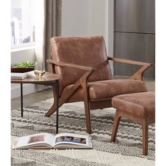 a chair and ottoman in a living room with a book on the floor next to it