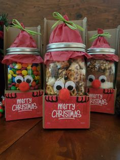 three jars filled with christmas treats sitting on top of a table