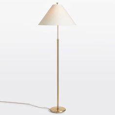 a floor lamp with a white shade on the base and a cord attached to it