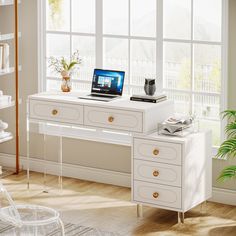 a white desk with a laptop on top of it next to a plant and bookshelf