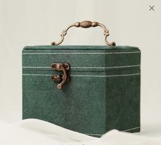 a green suitcase sitting on top of snow covered ground