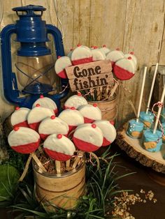 some cupcakes are sitting in a bucket on the table next to an old lantern