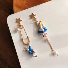 two pairs of earrings with cartoon characters on them