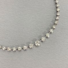 A classic and elegant everyday or occasional wear with graduating diamond sizes, this Space Necklace is a fresh take on a versatile piece of jewelry. All our necklaces have two locks for added security. Center Diamond Weight: 1.00 ct Center Diamond Color: I Center Diamond Clarity: SI (Slightly Included) Total Diamond Weight: 11.53 ct No. of Diamonds: 77 Diamond Color: H - J Diamond Clarity: SI - I (Slightly Included - Included) Metal: Platinum Metal Wt: 32.15 gms Setting: Prong Set Length: 15.75 Silver Single Strand Tennis Necklace, Dazzling Formal Necklaces, Classic Crystal Tennis Necklace With Brilliant Cut, Classic Crystal Tennis Necklace With Prong Setting, Diamond White Single Strand Round Cut Jewelry, Fine Jewelry Single Strand Diamond Necklace, Classic Crystal Tennis Necklace, Formal White Single Strand Diamond Necklace, Classic Crystal Diamond Necklace With Brilliant Cut