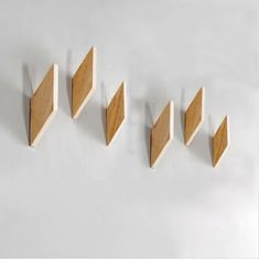 four pieces of wood sitting on top of a white surface next to each other in the shape of triangles