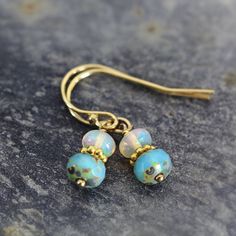 These handmade Ethiopian opal earrings are dainty yet exotic - they simply glow and will light you up with their fabulous opalescence. Featuring an exquisite Ethiopian 'Welo' opal sat above a gorgeous aqua glass bead, with a gold bead nestled between. These opals are the finest quality, flawless, AAA with superb inner fire - they catch the light with every movement and the rainbow of colours is quite mesmerizing. Very dainty, these iridescent drop earrings measure just 2.2cm from top to tail. Fi Ethiopian Opal Earrings, Iridescent Earrings, Gemstone Drop Earrings, Fairy Jewelry, Aqua Glass, Birthstone Earrings, Birthstone Earring, October Birthstone, Opal Earrings