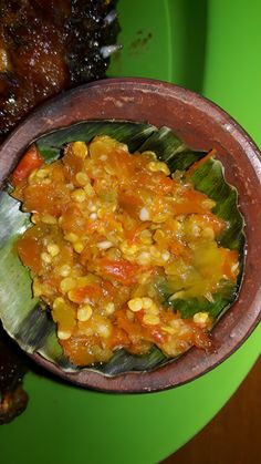 a bowl filled with food sitting on top of a green plate