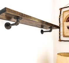 a wooden shelf mounted to the side of a wall next to a lamp and painting