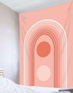 an orange and pink wall hanging over a bed