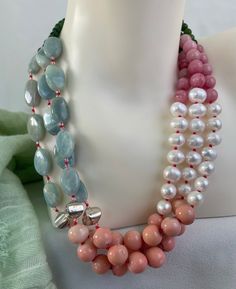 Aquamarine Jade Necklace hand knotted in red silk thread, 8 mm fresh water pearls, 1mm sterling silver cube beads,10 mm peach coral, 8 mm pink jasper, 4 mm green jade, 18 mm flat oval milky aquamarine with custom sterling silver findings and fastener. This one of a kind, triple strand necklace is 20 inches long plus 2.5 inch externder clasp, weight is 6.4 oz handcrafted in North Palm Beach, Florida by designer/ artist Christine Smith Multi-strand Pearl Necklace With Natural Stones For Gifts, Gift Multi-strand Pearl Necklace With Natural Stones, Multi-strand Pearl Necklace With Gemstone Beads, Double Strand Pearl Necklace With Gemstone Beads, Elegant Coral Gemstone Beaded Necklaces, Elegant Coral Beaded Necklaces With Gemstone, Elegant Coral Pearl Necklace With Round Beads, Elegant Single Strand Coral Beads, Elegant Hand-strung Coral Necklace