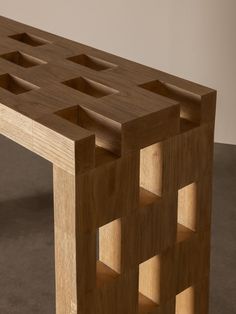 a wooden table with several compartments on the top and one section cut out into squares