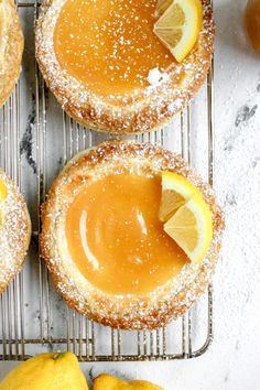 lemon custard tarts with powdered sugar and oranges on the side