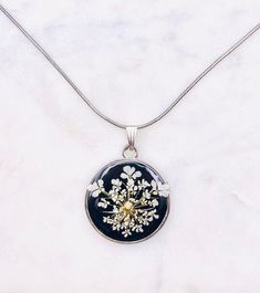 This beautiful black and white Queen Anne's lace mustard seed necklace is perfect for any occasion!  Share your faith and your love of nature everywhere you go. This beautiful handmade resin necklace makes the perfect gift for mom, sister, wife, best friend, or just a reminder of your own inner beauty and faith.  Necklace is handmade with resin, real flowers, mustard seeds, and a sterling silver hypoallergenic snake chain.  Necklace: Length: 20 inches long  Width: 1.2mm 925 Sterling silver plated  with lobster clasp Please contact me if you have any questions or requests. Due to the handmade nature of the resin process no two necklaces will ever be exactly identical. Please keep in mind that there may be some minor imperfections in the resin, such as tiny air bubbles SHOP DESCRIPTION: Resi Faith Earrings, Sister In Christ, Mustard Seed Necklace, Ocean Earrings, Faith Jewelry, Round Necklace, Resin Necklace, Gifts For Sister, Christian Jewelry