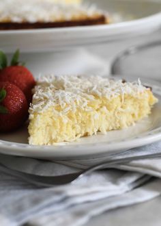 there is a piece of cake and two strawberries on the plate next to it