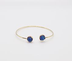 The Druzy Navy Blue Stone End Cuff Bracelet is a lightweight bracelet that is great to use for stacking with other bracelets. It is a beautiful bracelet that will add a touch of elegance to any outfit. Elegant Blue Stackable Crystal Bracelet, Elegant Blue Cuff Bracelet For Gift, Elegant Blue Wrap Bracelet As Gift, Elegant Blue Wrap Bracelet As A Gift, Blue Stackable Wrap Bracelet As Gift, Adjustable Blue Stackable Wrap Bracelet, Adjustable Blue Stackable Stretch Bracelet, Blue Adjustable Stackable Stretch Bracelet, Handmade Blue Bangle Jewelry