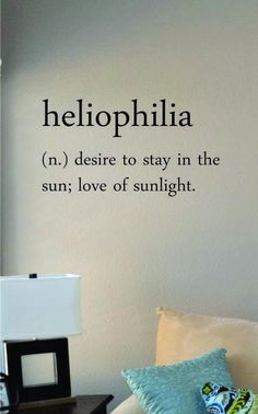 a living room with a couch, lamp and wall decal that says helloophilia