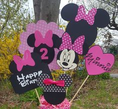 minnie and mickey mouse birthday decorations in a basket with pink bow on the grass outside