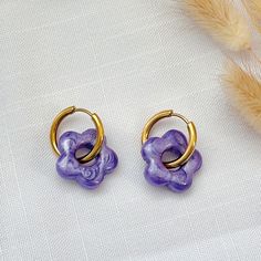 Purple Resin Flower Charm Huggie Hoop Earrings - Hypoallergenic Stainless Steel, Hypoallergenic Earrings, Handmade Jewelry, Gift For Her Add a touch of charm to your style with these delightful colored resin flower-shaped charm huggie hoop earrings. Each earring features a meticulously crafted flower charm made from high-quality uv resin, suspended from a sleek 19mm stainless steel huggie hoop. The stainless steel hoop offers durability and a hypoallergenic design, making it ideal for those with Purple Resin, Earrings Hypoallergenic, Handmade Jewelry Gift, Resin Charms, Colorful Jewelry, Resin Flowers, Everyday Accessories, Hypoallergenic Earrings, Huggie Hoop Earrings