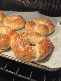 freshly baked bagels sitting on top of a baking sheet in an oven, ready to go into the oven