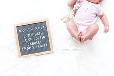 a baby laying next to a sign that says month no a loves bath laughs often babies enjoy - target